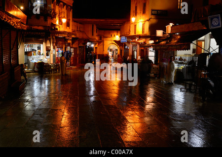 Cafés à Bab Boujeloud porte bleue sur une nuit humide à fes el bali medina maroc Banque D'Images