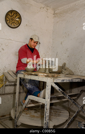 Jeter des pots en argile travailleur tajine sur une roue qui tourne dans une boutique Médina Fès Maroc Banque D'Images