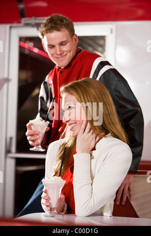 Teen couple avec des milkshakes à diner, style années 50 Banque D'Images