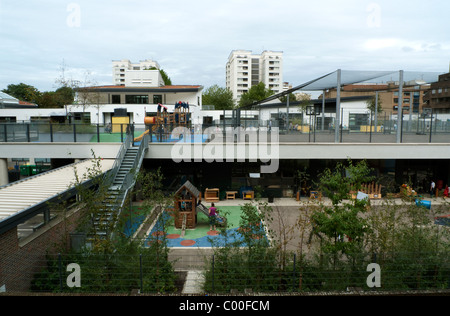 Enfants jouant dans le terrain de jeu coloré à l'école Prior Weston Golden Lane Campus près de Barbican Estate, Islington, Londres EC1 Angleterre KATHY DEWITT Banque D'Images