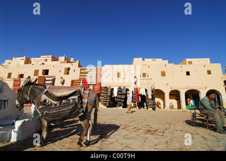 L'Algérie, Ghardaïa, animal de travail avec tapis et variété des objets exposés à la vente au marché Banque D'Images