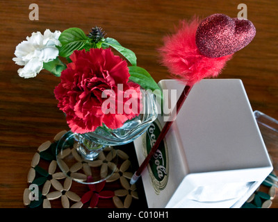 Table Valentine mexicain lunatique avec oeillets rouge et blanc vintage Coca Cola porte-serviettes & coeur avec plume rouge Banque D'Images