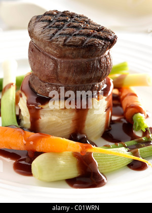 Tournedo Steak sur pommes de terre dauphinoise avec bébé bébé carottes poireaux et sauce Banque D'Images