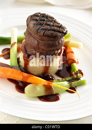 Tournedo Steak sur pommes de terre dauphinoise avec bébé bébé carottes poireaux et sauce Banque D'Images