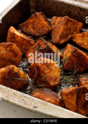 Pommes de terre et les patates douces dans une rôtissoire Banque D'Images