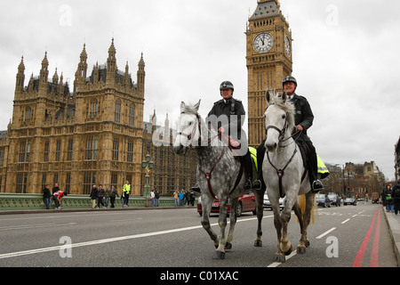 Deux policier à cheval à pied à travers le pont de Westminster devant les Chambres du Parlement, au centre de Londres Banque D'Images