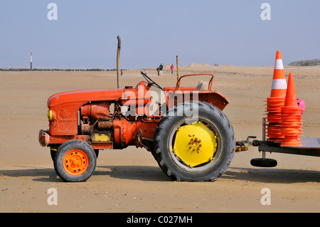 Tracteur rouge sur la plage de Ouistreham en Normandie en France pour le transport de petits bateaux Banque D'Images