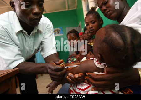 Un agent de santé vaccine un enfant contre la rougeole à l'Masuba centre de santé dans la ville de Makeni, Sierra Leone Banque D'Images