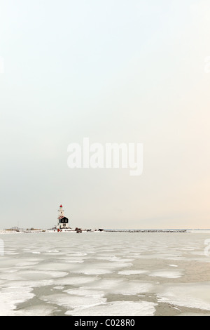 Dutch paysage d'hiver avec la mer gelée et le phare Banque D'Images