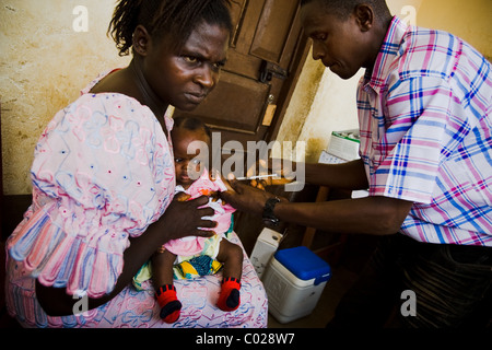 Un agent de santé vaccine un enfant contre la rougeole au centre de santé communautaire à Binkolo Binkolo, Sierra Leone Banque D'Images