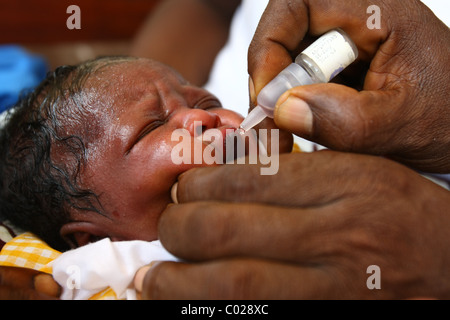 Un agent de santé vaccine un enfant contre la polio à l'Binkolo community health centre dans le village de Binkolo Banque D'Images