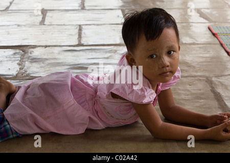 Petite fille couchée sur chaussée à Nyaung Oo, la Pagode Shwezigon, Bagan, Birmanie Myanmar Banque D'Images