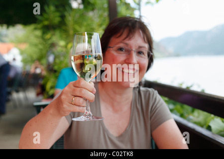 Femme avec un verre de vin blanc dans un café en bord de mer sur le Danube, Spitz, Wachau, Waldviertel, Basse Autriche, Autriche, Europe Banque D'Images