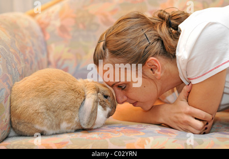 Fille de câlins avec un nain européen Lapin (Oryctolagus cuniculus), l'amour des animaux Banque D'Images