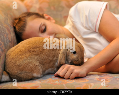 Fille de câlins avec un nain européen Lapin (Oryctolagus cuniculus), l'amour des animaux Banque D'Images