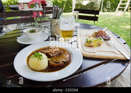 Rôti de porc aux pommes de terre et d'une boulette un verre de bière dans un café en plein air, une cuisine bavaroise, Bavaria, Germany, Europe Banque D'Images