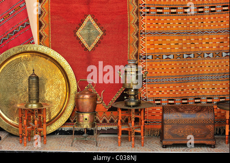Un concessionnaire vend ses marchandises au souk, bazar, tapis, plaques de laiton, bidons et des coffres, le Maroc, l'Afrique Banque D'Images