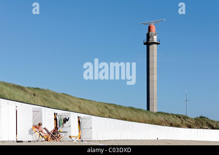 Deux femmes assises sur des chaises longues en face de cabines de plage blanche de parler, Westkapelle, presqu'île de Walcheren, province de Zélande Banque D'Images