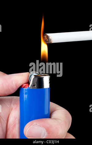 Une personne allume une cigarette avec un briquet au butane. Banque D'Images