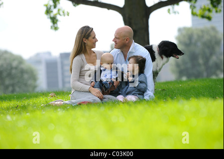 Famille heureuse avec une fillette de trois ans, six mois et un chien Banque D'Images