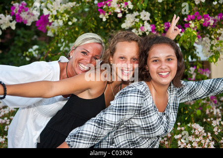 Portrait d'une mère avec deux 13 ans filles devant des fleurs Banque D'Images