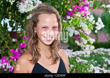 Portrait of a 13 ans en face de fleurs Banque D'Images