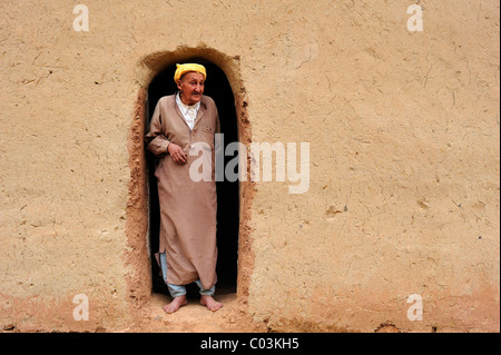 Personnes âgées homme berbère portant un turban à la recherche de l'entrée de sa maison de terre, Haut Atlas, Maroc, Afrique Banque D'Images
