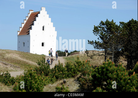 Dunes avec la tour de la noctuelle de l'église enfouie englouti avec les cyclistes, Skagen, Jutland, Danemark, Europe Banque D'Images