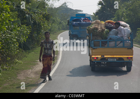 Un homme marche du Bangladesh sur le chemin de la route des camions tout en Chittagong Banque D'Images