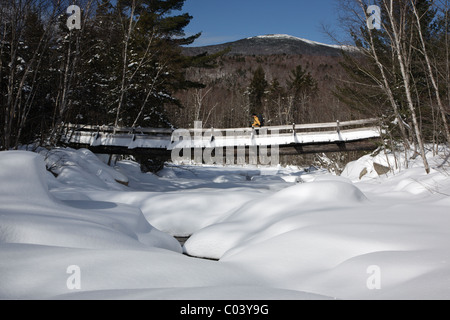 Randonneur traversant l'hiver dans la passerelle Pemigewasset Wilderness des Montagnes Blanches, New Hampshire Banque D'Images