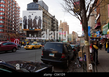 Canal Street dans le quartier chinois de New York entre Baxter et Mulberry Streets à ouest avec de grands panneaux Beatles en arrière-plan Banque D'Images
