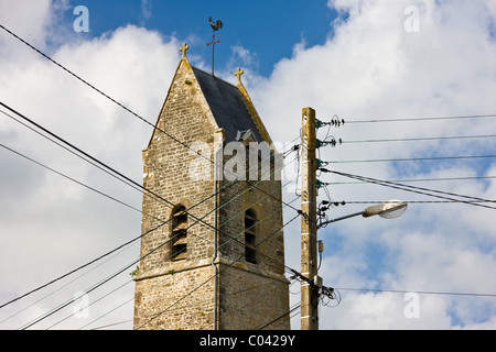Téléphone et le fil d'alimentation, câbles sur poteau télégraphique en face de l'église dans Houesville, Normandie, France Banque D'Images