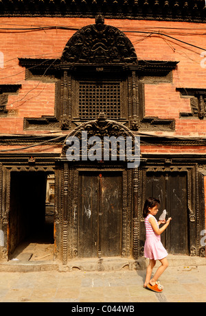 Jeune fille en passant devant l'ancien bâtiment , peuples vit ( l ) les Népalais , la vie dans la rue à Katmandou kathmandu , Népal , Banque D'Images