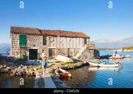 Fille qui marche vers la chambre sur l'île, Bjelila, Lustica, Bouches de Kotor, Monténégro Banque D'Images