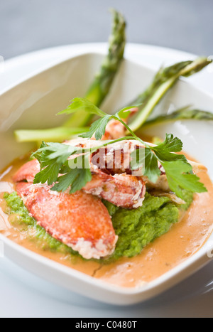 Pinces de crabe pelés à partir de leurs griffes servi sur un lit de purée de petits pois et une réduction de la sauce crabe Banque D'Images