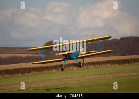 Un vintage PT13-D biplan Stearman volant à Compton Abbas aérodrome en Angleterre Banque D'Images