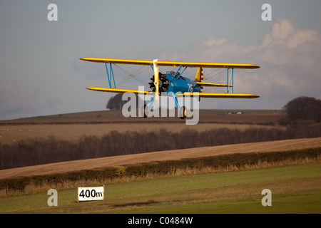 Un vintage PT13-D biplan Stearman volant à Compton Abbas aérodrome en Angleterre Banque D'Images