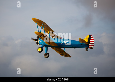 Un vintage PT13-D biplan Stearman volant à Compton Abbas aérodrome en Angleterre Banque D'Images