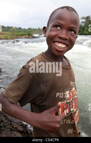 Un garçon de l'école joue le long des rives du Nil au chutes de Bujagali, en Ouganda, en Afrique de l'Est. Banque D'Images