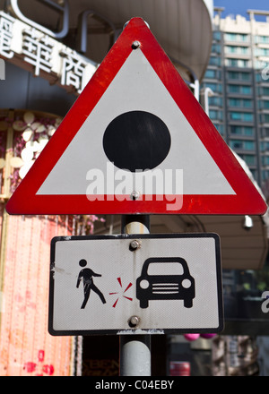 Curieux panneau routier à Hong Kong à un passage pour piétons Les piétons d'avertissement du risque d'un accident Banque D'Images