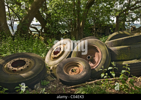 Une collection de vieux pneus et roues d'un dumping aux côtés d'un chemin de campagne dans le Yorkshire du Nord Banque D'Images