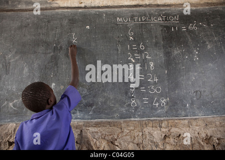 Un élève apprend à mathmatics Abia - l'école primaire, l'Ouganda, District de Amuria Afrique de l'Est. Banque D'Images