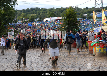 Festivaliers marcher dans la boue au festival de Glastonbury, Somerset, UK Banque D'Images