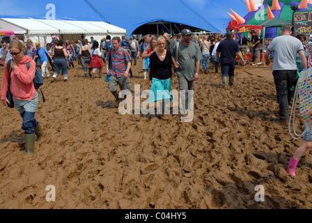 Les gens aux prises avec de la boue épaisse au festival WOMAD, Malmesbury, Wiltshire, Royaume-Uni Banque D'Images