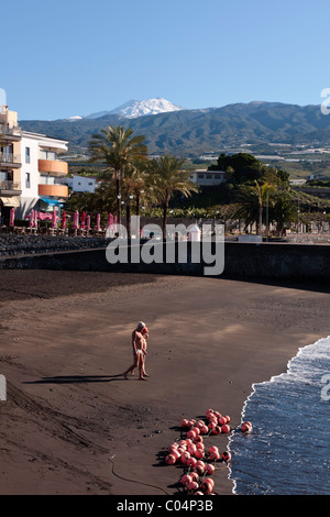 Deux nageurs la tête en bas, la plage de San Juan et Teide est recouverte de neige derrière sur Tenerife, Canaries, Espagne Banque D'Images