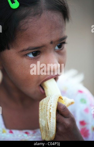 Fille manger une banane de l'Andhra Pradesh en Inde du Sud Banque D'Images