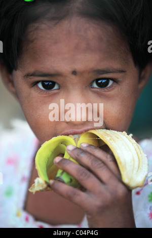 Fille manger une banane de l'Andhra Pradesh en Inde du Sud Banque D'Images