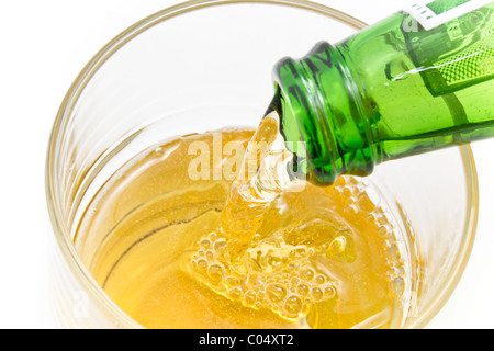 Servir la bière à partir d'une bouteille de bière verte dans un verre Banque D'Images