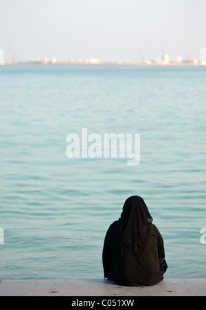 Une femme vêtue de Hijab robe musulmane islamique se trouve sur la Corniche à Doha, Qatar Banque D'Images