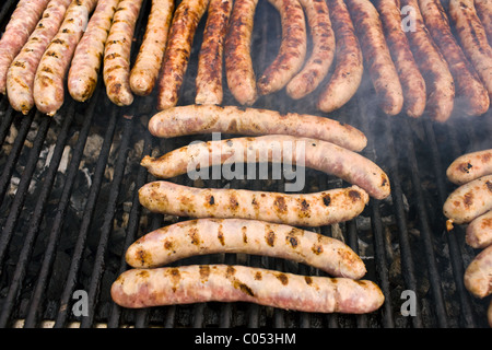Saucisses grillées saucissons cuits sur une plaque chauffante est en vente comme un casse-croûte au marché de fermiers en Normandie, France Banque D'Images